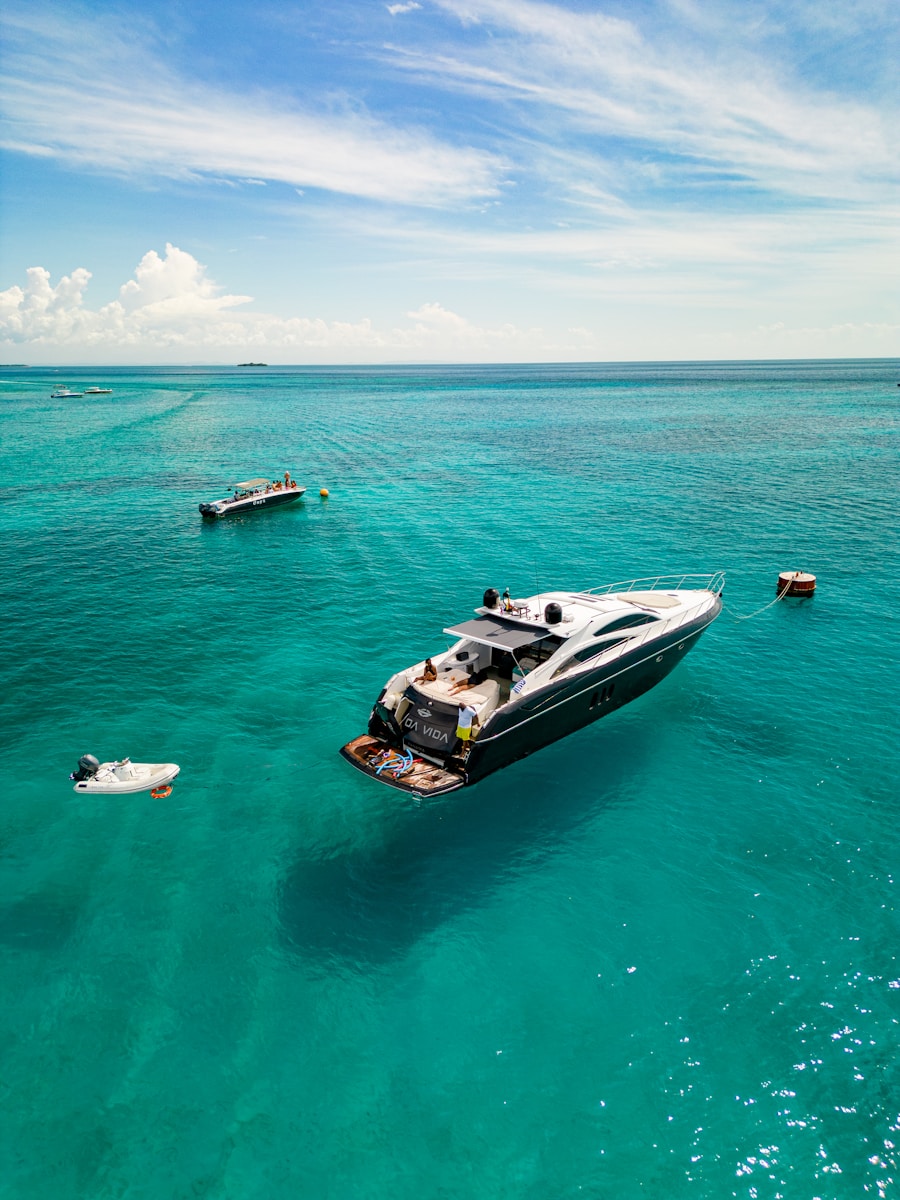Luxury yacht anchored in clear turquoise ocean water.